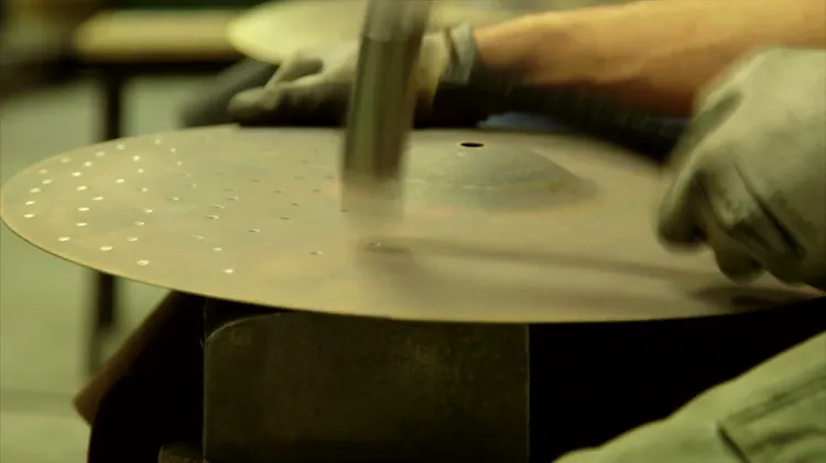 Craftsman hand hammering a cymbal bow